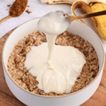 Adding protein paste dissolved in water to cooked oatmeal.