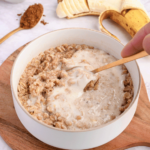Mixing protein powder paste into cooked oats.