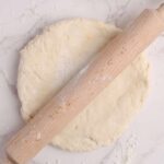 Rolling high protein Greek yogurt dough into a round pizza