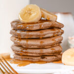 Stack of fluffy Oat Flour Pancakes with maple syrup and banana