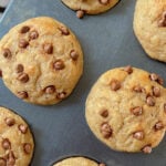 Healthy chocolate chips protein muffins after baking, in a lined muffin pan.