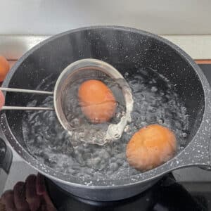 Lowering eggs into hot water