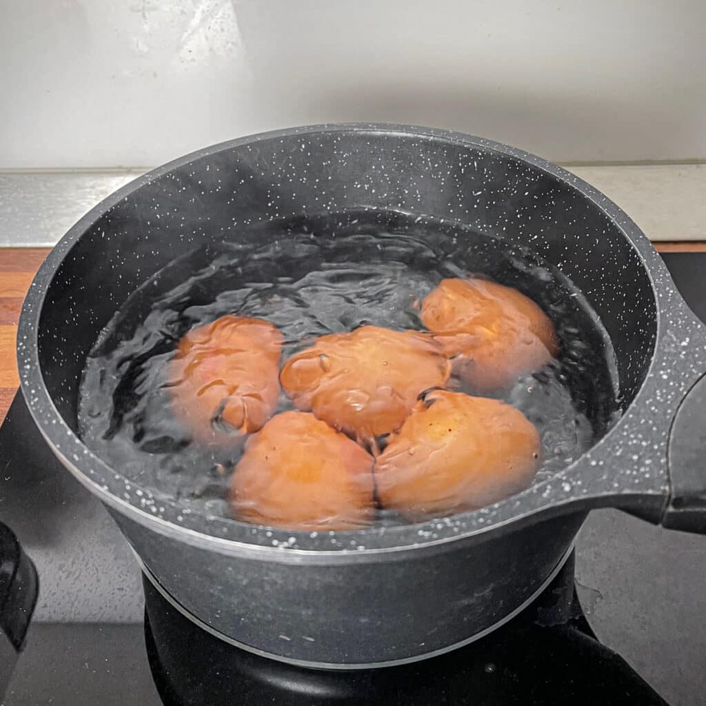 Five boiling eggs in pot