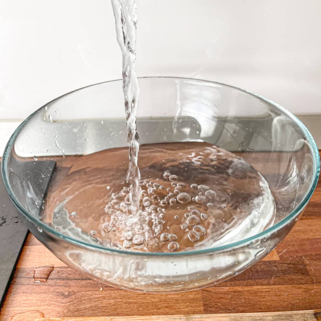 Adding cold water to bowl for ice bath