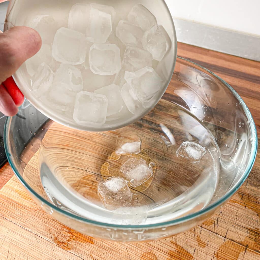 Adding ice to water for ice bath