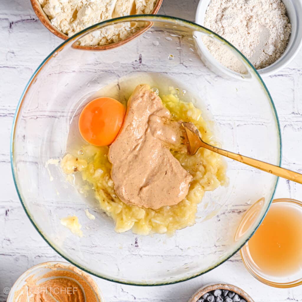 Adding egg and peanut butter to mashed banana