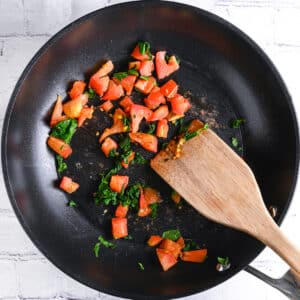 Sautéing spinach and tomatoes