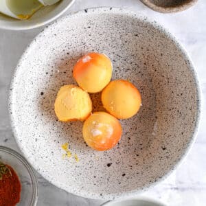 Four hard-boiled egg yolks placed in a mixing bowl, ready for deviled egg preparation.