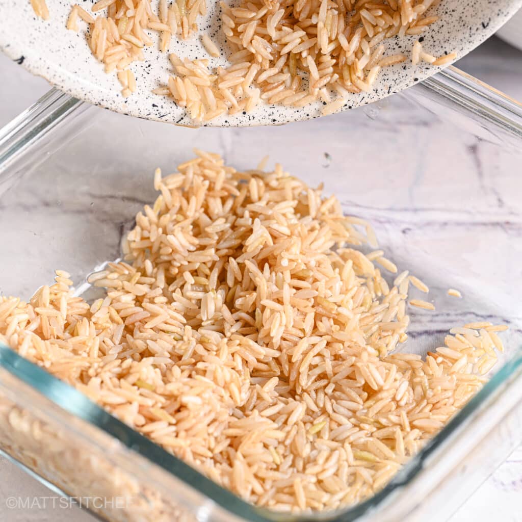 Adding rice to cook in water in a glass bowl.