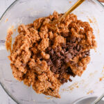 A bowl of thick, chunky protein cookie dough with dark chocolate chips before shaping.