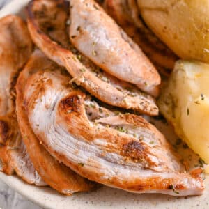 Turkey steak served with baked potatoes and seasoned with dried herbs