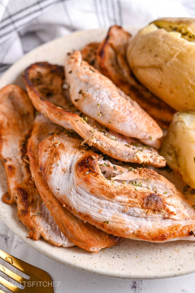 Pan-fried turkey steaks served with baked potatoes