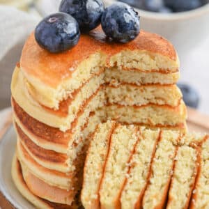 Soft, thick, and golden-brown keto protein pancakes with blueberries on top.