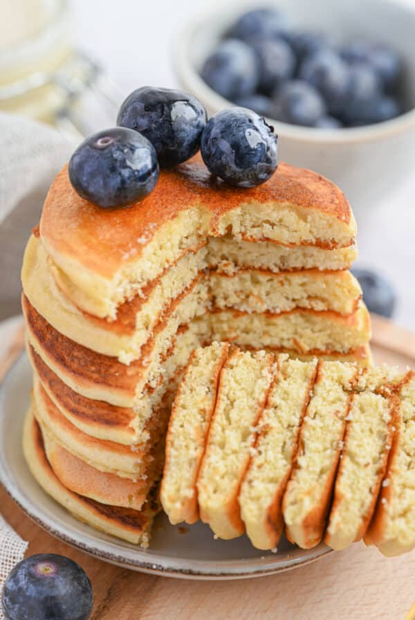 Soft, thick, and golden-brown keto protein pancakes with blueberries on top.