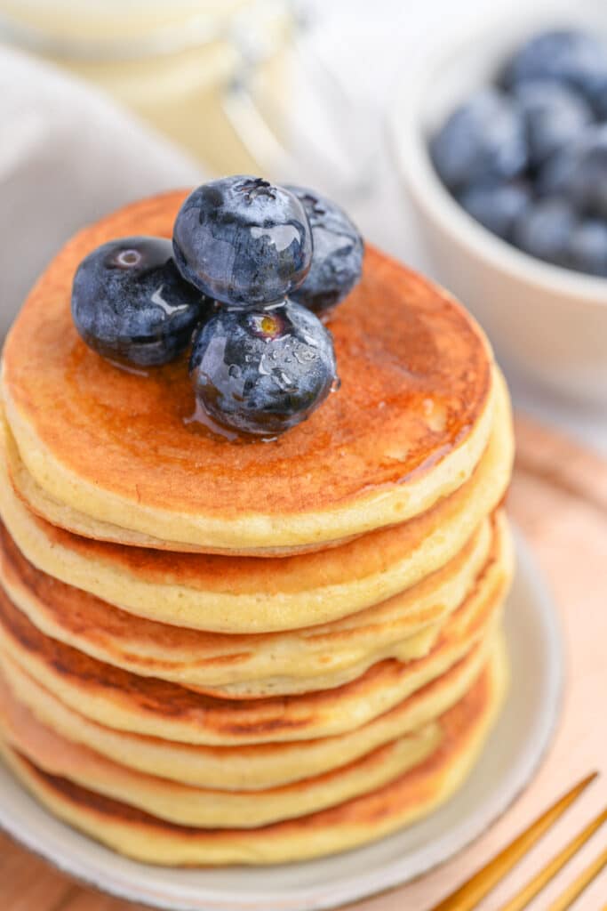 A stack of flourless protein pancakes made with whey protein powder, served with blueberries.