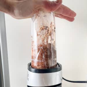 Blending cottage cheese with cocoa powder and maple syrup.