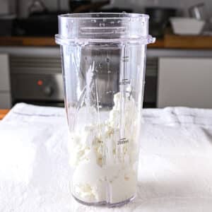 A blender filled with rich, creamy cottage cheese before adding eggs, showcasing the first step in making a simple two-ingredient cottage cheese flatbread.