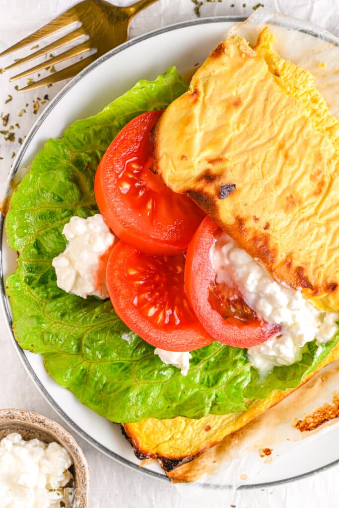 A fresh and healthy open-faced sandwich made with cottage cheese flatbread, crisp lettuce, juicy tomato slices, and extra cottage cheese for a protein-packed meal.