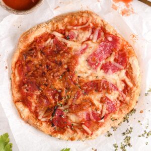 Freshly baked cottage cheese pizza – A golden brown, crispy cottage cheese pizza crust with melted mozzarella and turkey salami.