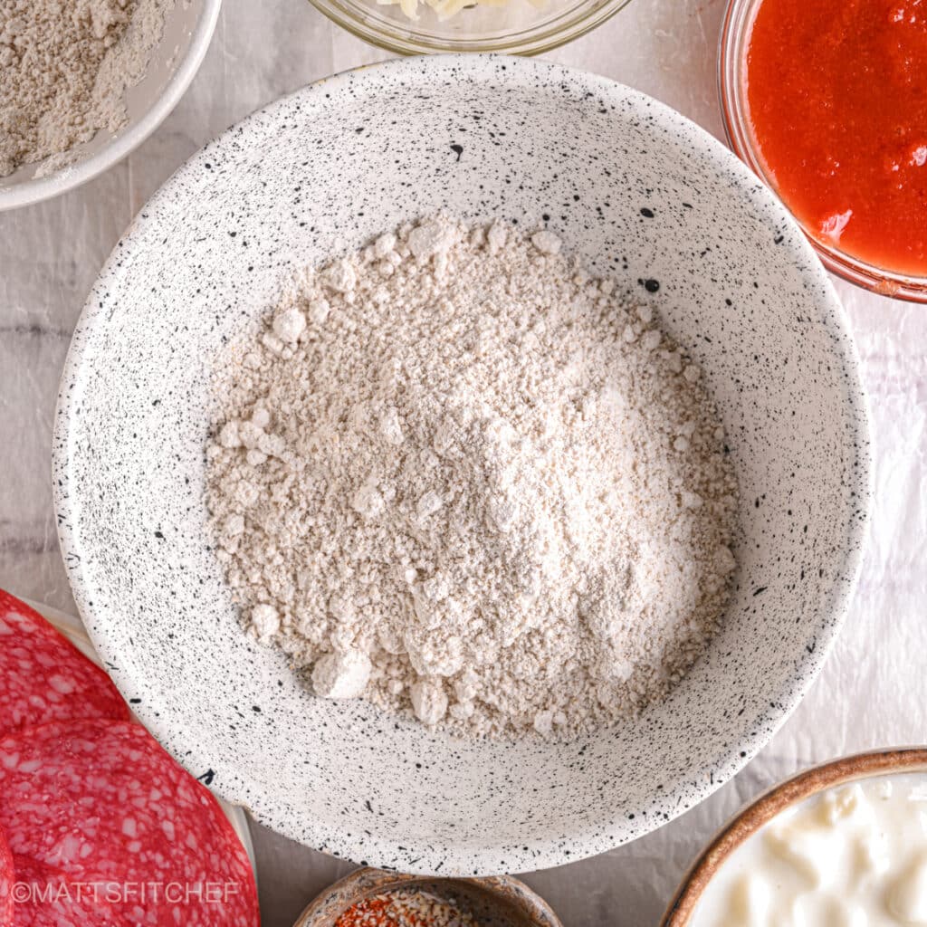 Whole wheat flour in a bowl – A close-up of whole wheat flour, the base ingredient for a high-protein cottage cheese pizza crust.