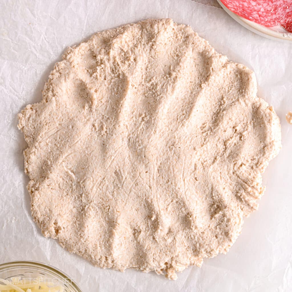 Rolled-out pizza dough – A homemade high-protein pizza crust made from cottage cheese, shaped and ready for toppings.