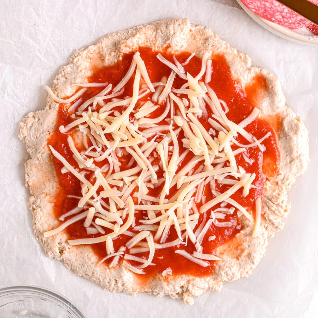 Adding shredded mozzarella cheese – Low-fat shredded mozzarella cheese sprinkled over a macro-friendly cottage cheese pizza.