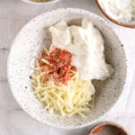 Taco seasoning sprinkled over cheese and cottage cheese – Bold and flavorful taco seasoning added to enhance the queso dip.