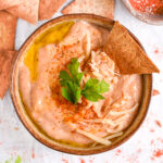 Dipping a chip into cottage cheese queso – A crispy pita chip scooping up creamy, high-protein queso.
