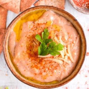 Finished cottage cheese queso with toppings &ndash; A smooth, cheesy queso dip garnished with fresh parsley and extra cheese.