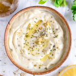 Smooth and creamy Greek yogurt ranch dressing in a rustic bowl, ready to use as a low calorie dip or dressing.