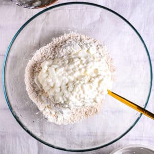 Adding cottage cheese to dry ingredients for high-protein bagels.