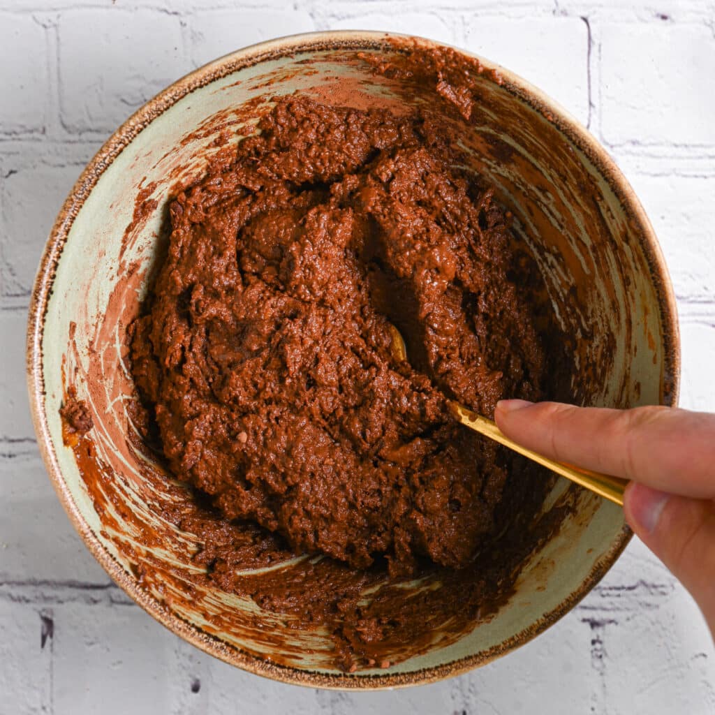 Mixing sweet potato brownie batter until smooth.