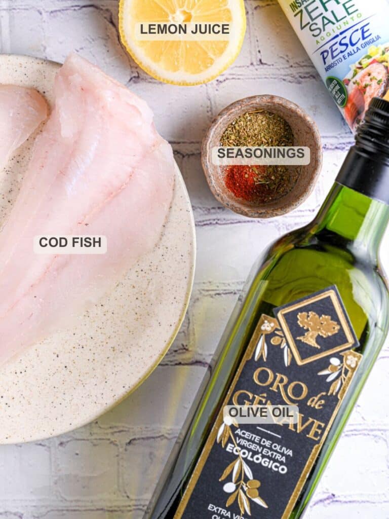 Ingredients for baked cod recipe – Cod fillet, olive oil, lemon juice, and seasonings displayed on a kitchen counter for a simple baked cod recipe.