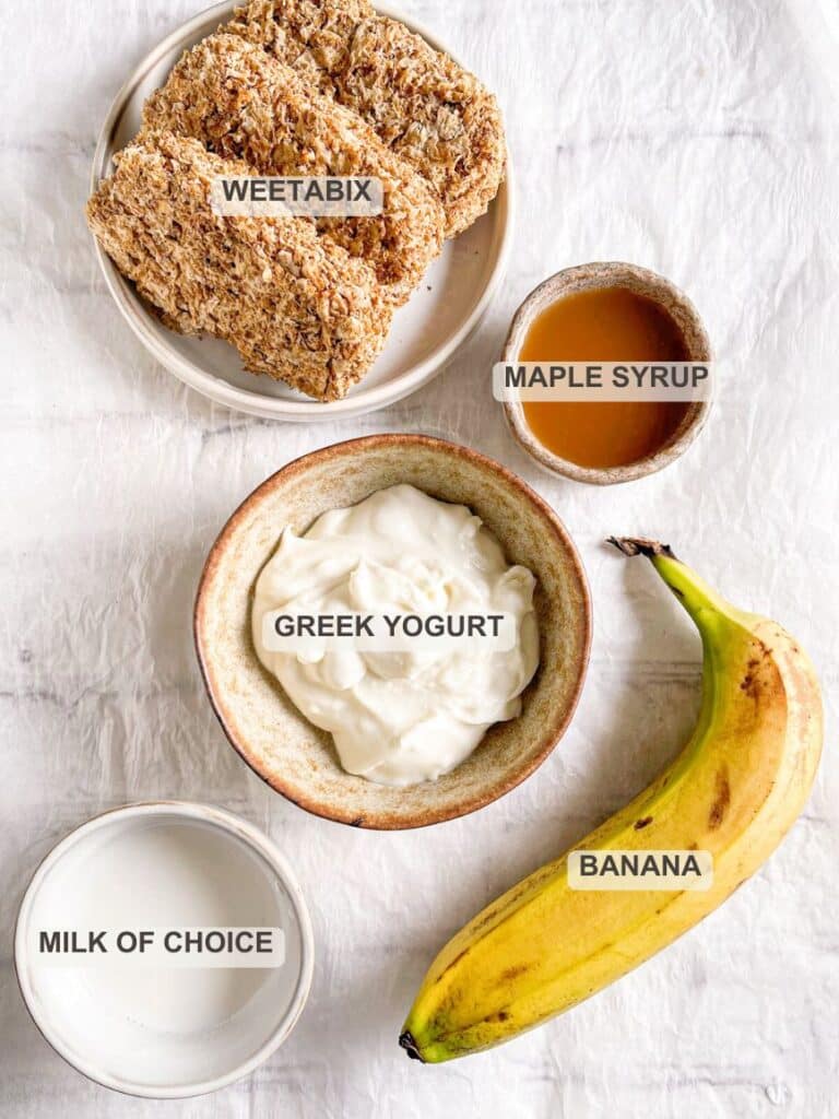 Ingredients for Overnight Weetabix laid out – A flat lay of all ingredients: Weetabix biscuits, Greek yogurt, banana, maple syrup, and milk.