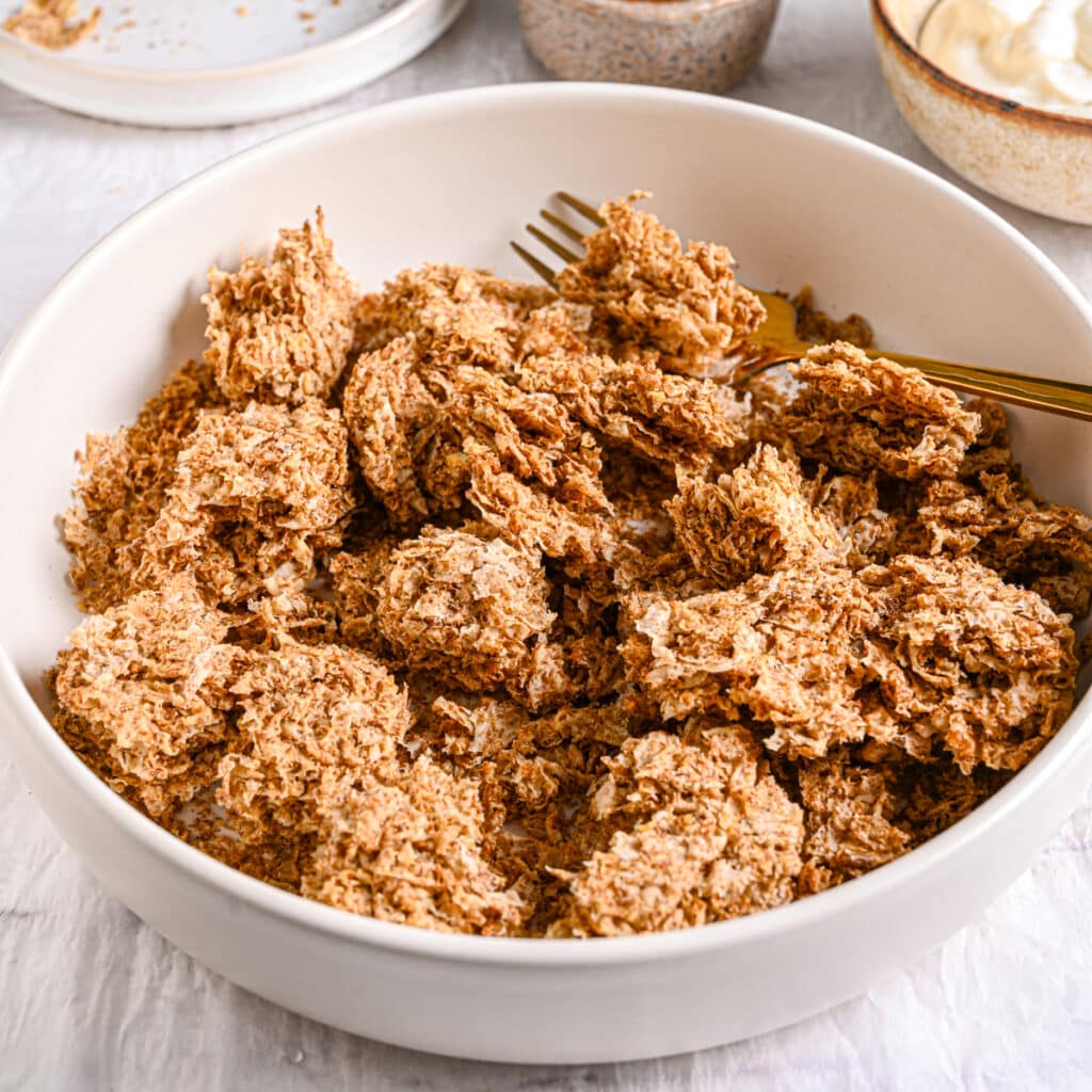 Weetabix crumbled in a bowl – A close-up of broken Weetabix pieces in a bowl, showing their texture before mixing.