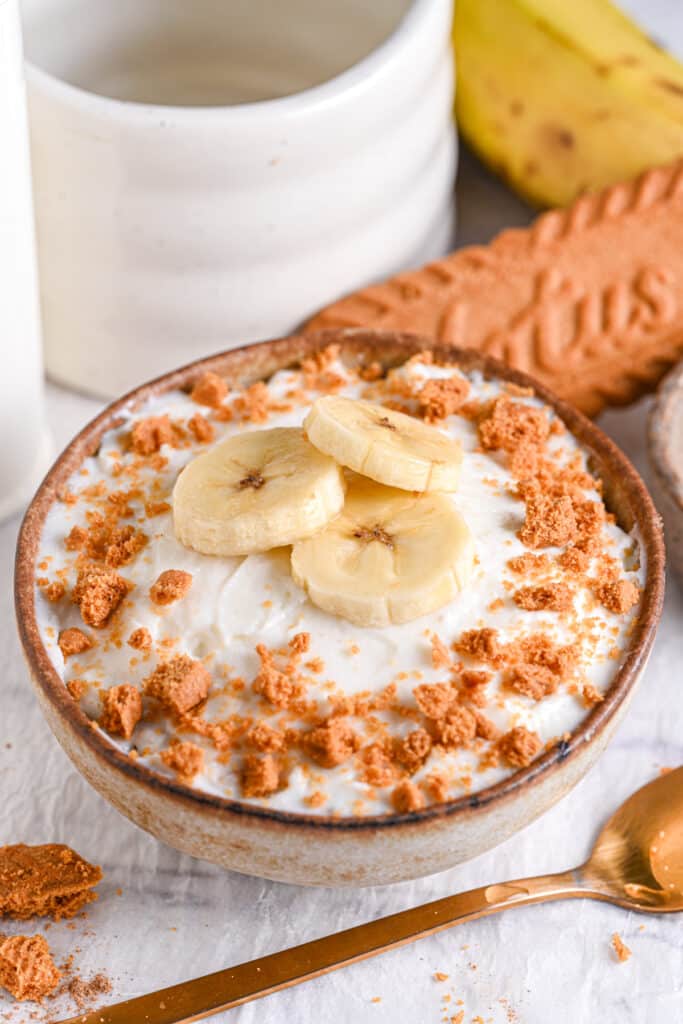 Final Overnight Weetabix topped with banana and Biscoff crumbs – A bowl of Biscoff overnight Weetabix garnished with banana slices and crushed Biscoff biscuits.