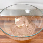 Greek yogurt topped with chocolate protein powder in a bowl, showing the simple two-ingredient mousse preparation.