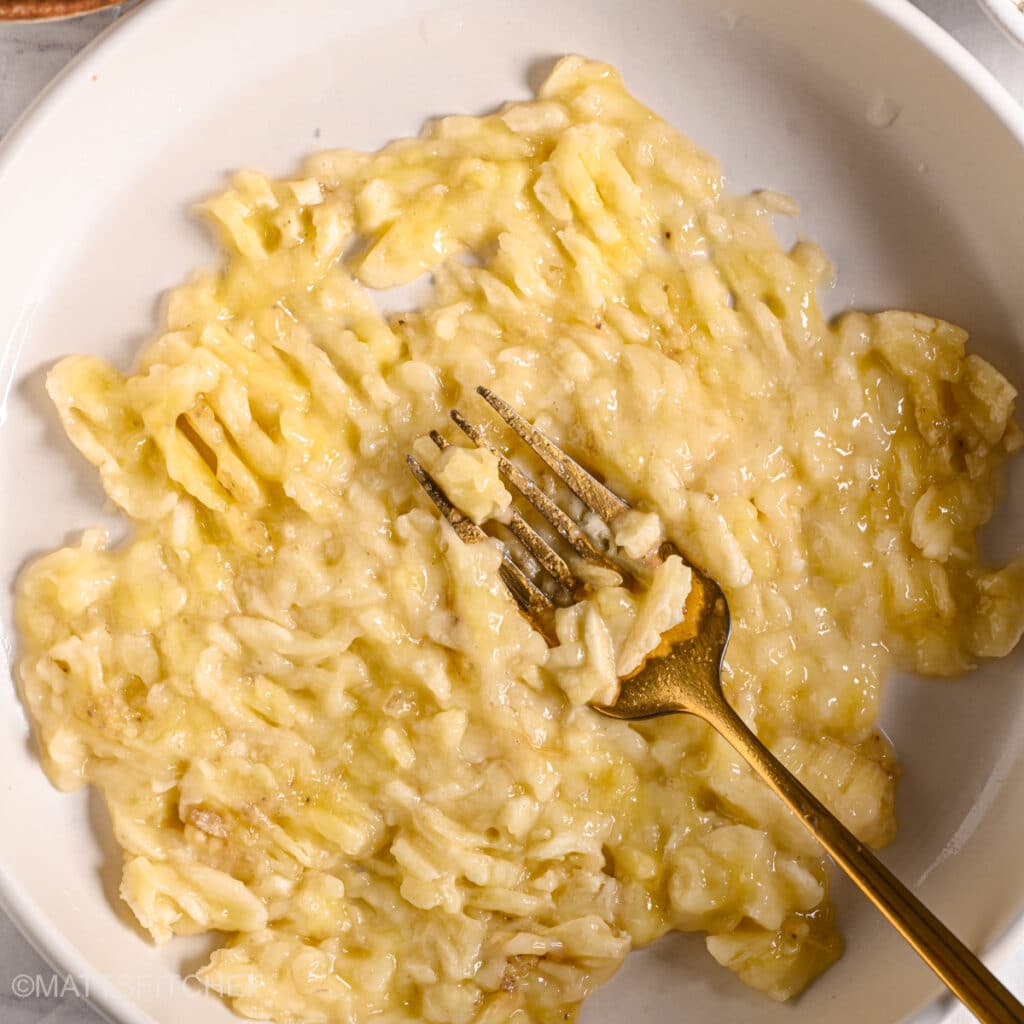 Fully mashed bananas in a bowl for cake batter.