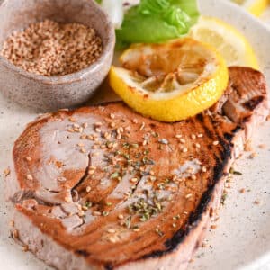 Seared tuna steak with sesame seeds &ndash; Perfectly cooked tuna steak with a golden crust, garnished with sesame seeds and lemon.