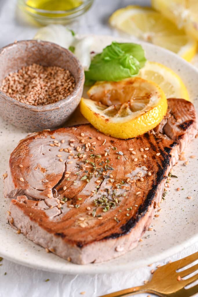 Seared tuna steak with sesame seeds &ndash; Perfectly cooked tuna steak with a golden crust, garnished with sesame seeds and lemon.