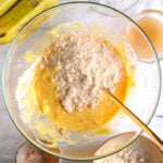 Adding blanched almond flour to mashed bananas and wet ingredients, to make banana bread batter.