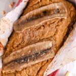 Almond Flour Banana Bread after Baking in a Red Metal Loaf Pan Lined with Parchment Paper