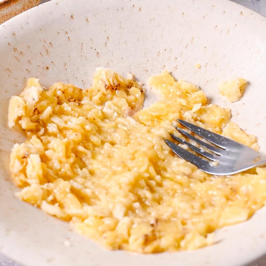 Ripe bananas mashed with a fork in a bowl