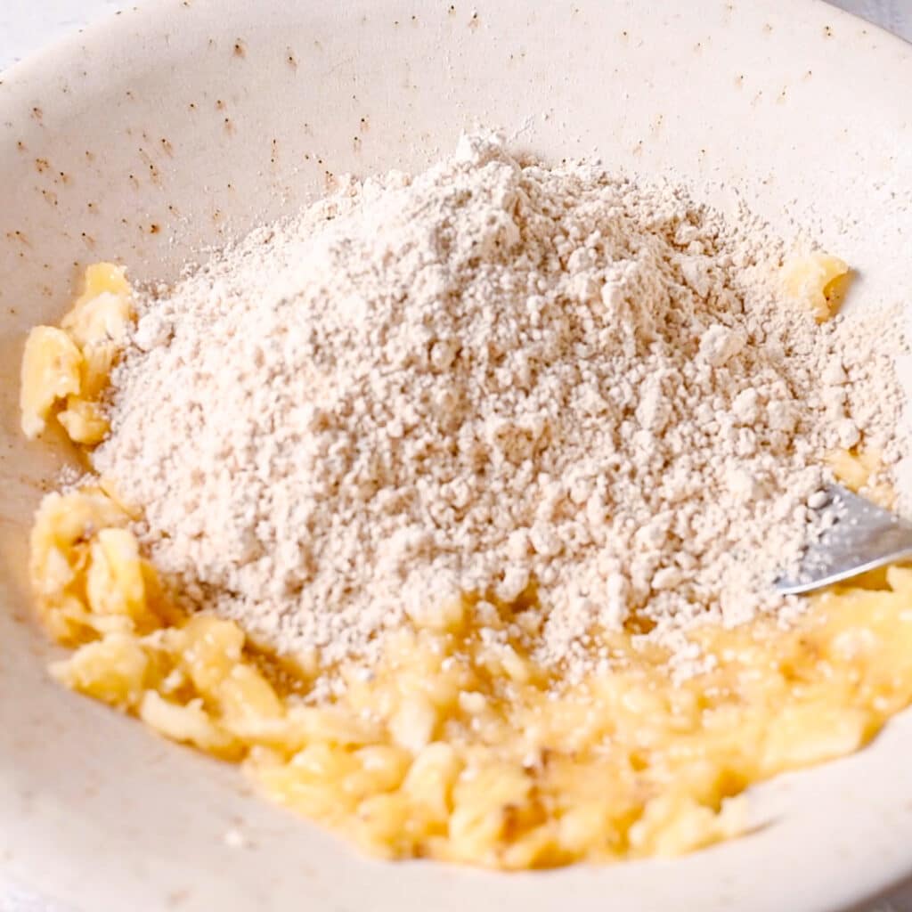 Adding self-rising flour to mashed bananas for 3 ingredient banana bread