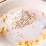 Adding milk to mashed bananas and flour to make easy banana bread moist
