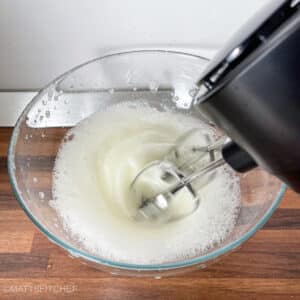 Beating egg whites with electric mixer before adding them to pancake batter.