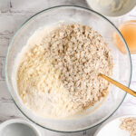 Adding rolled oats and oat flour or protein powder to the wet mixture, before mixing and adding strawberries for bars.