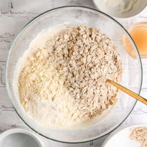 Adding rolled oats and oat flour or protein powder to the wet mixture, before mixing and adding strawberries for bars.