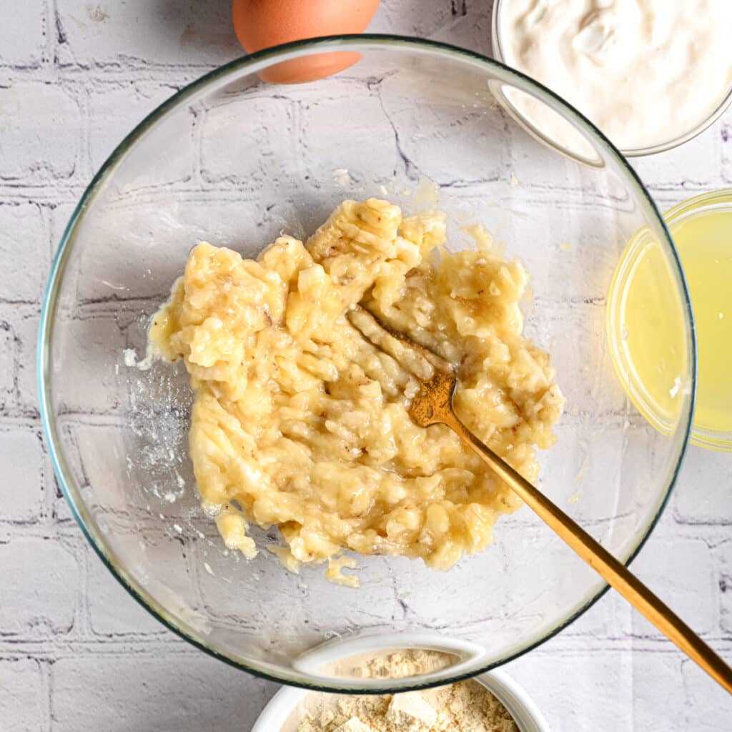 Mash bananas for making protein muffins with Greek yogurt