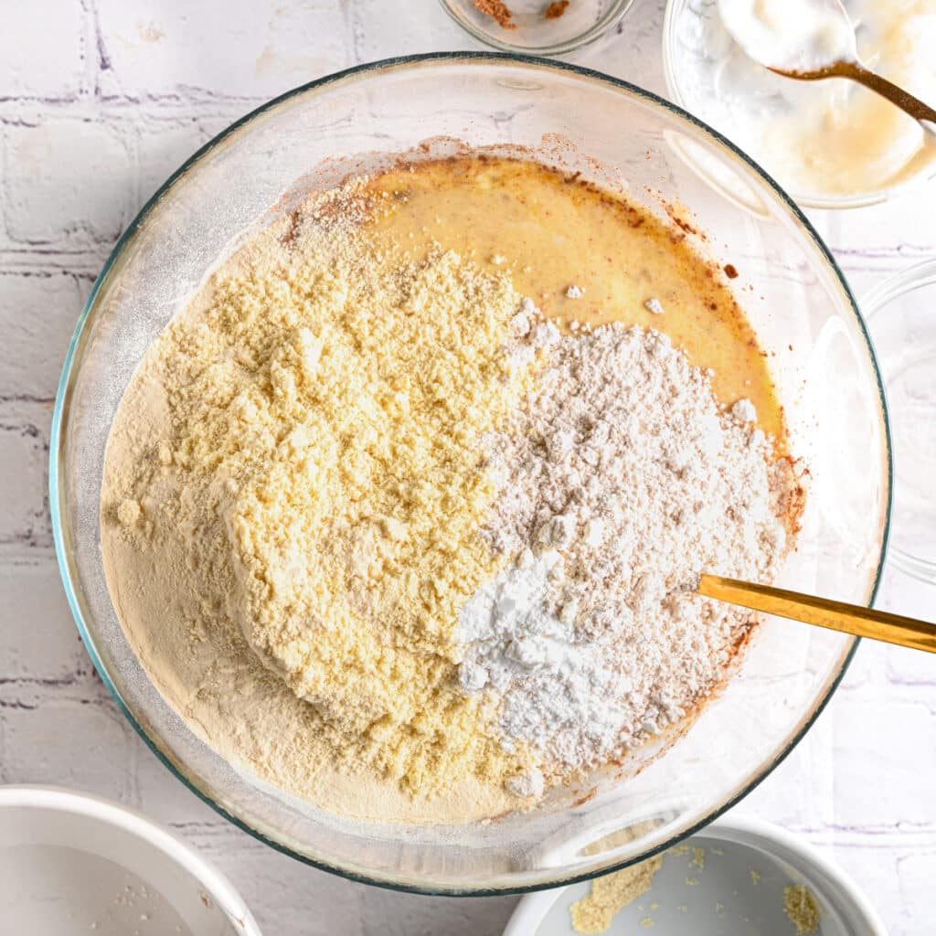 Adding protein powder and oat flour to the Greek yogurt batter, before mixing.